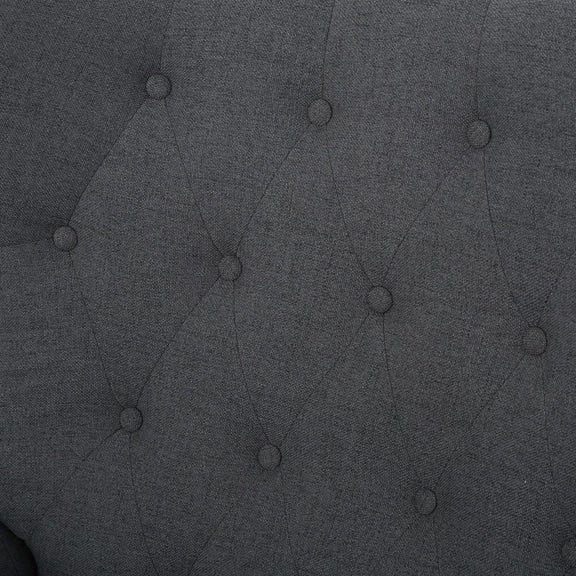 Dark gray tufted upholstery fabric close-up with button details.