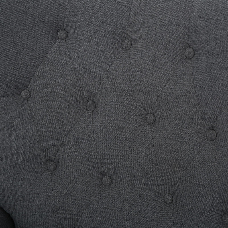 Dark gray tufted upholstery fabric close-up with button details.