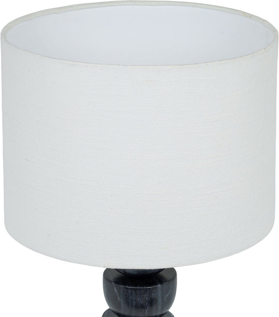 Table lamp close-up: white fabric drum shade over stacked dark marble base