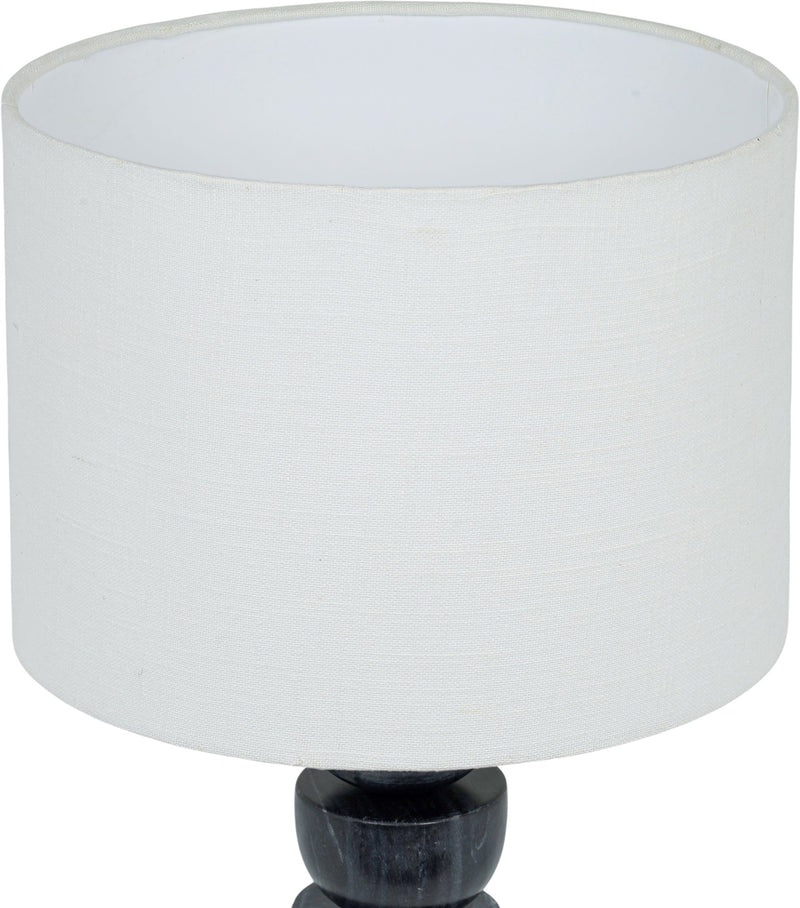 Table lamp close-up: white fabric drum shade over stacked dark marble base