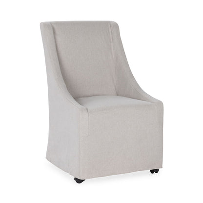 Upholstered rolling dining chair in light beige fabric, three-quarter view with wheels