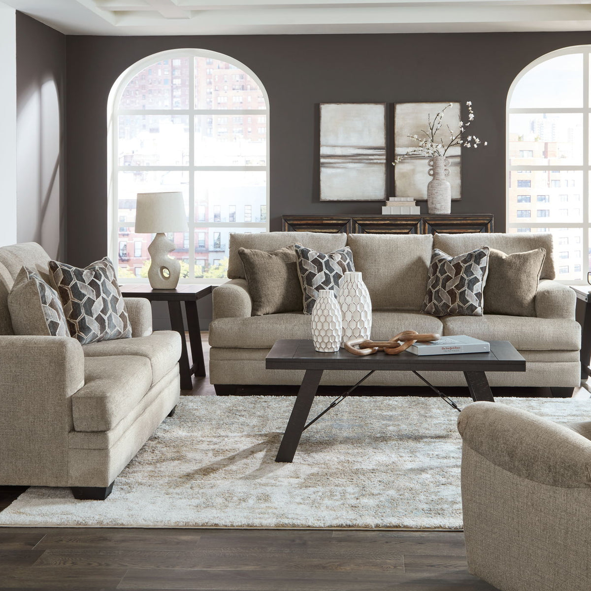 Taupe fabric sofa set with chaise chair and ottoman, viewed from the front with coffee table.