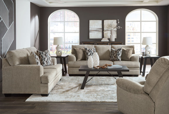 Taupe fabric sofa set with chaise chair and ottoman, viewed from the front with coffee table.