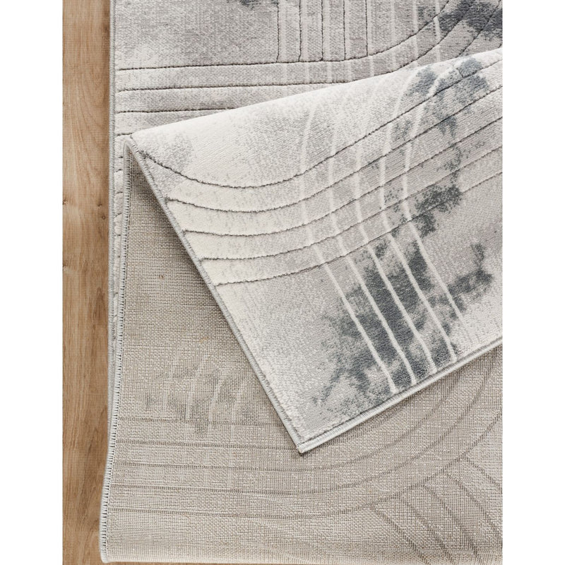 Gray area rug corner detail with textured geometric lines and blue-gray accents.