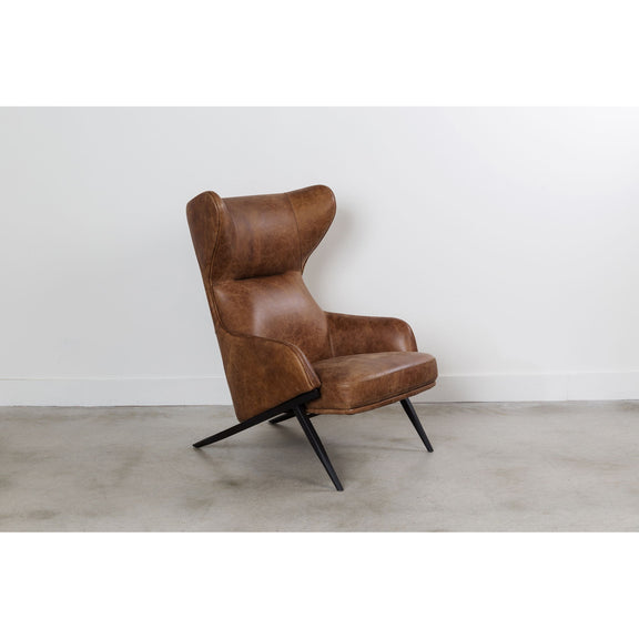 Brown leather accent chair with orange lumbar pillow and black metal legs