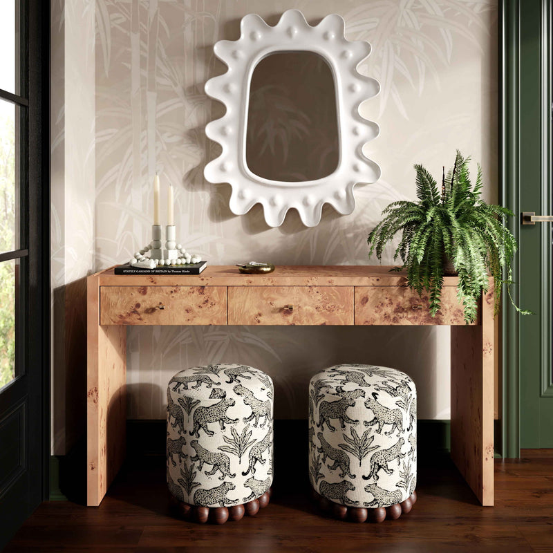 Set of two gray animal-print ottomans with dark wood ball bases.