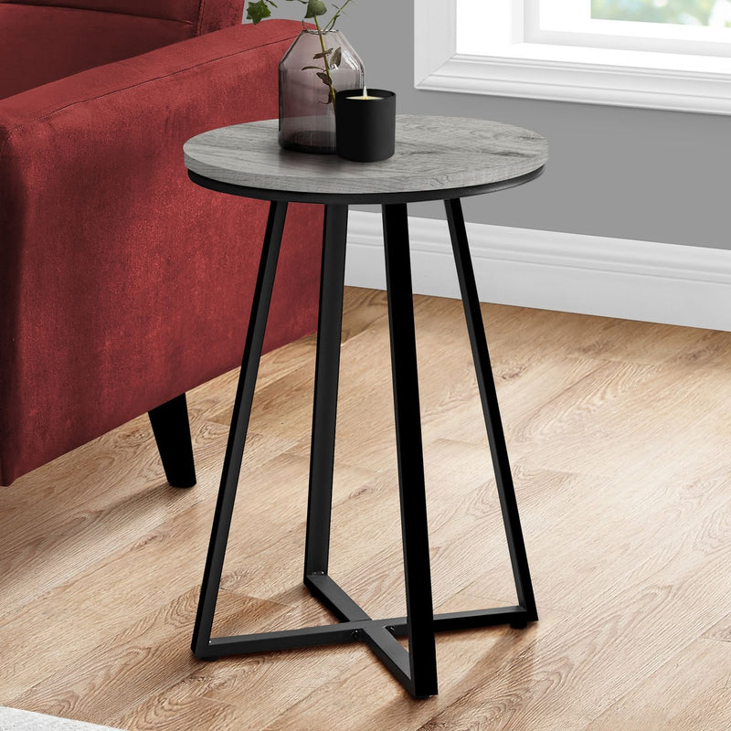Round accent side table with light gray top, black tapered legs, and cross-brace