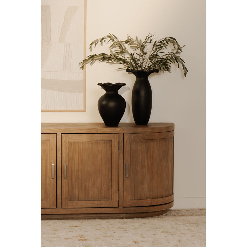 Natural wood media cabinet with two-door storage and curved base, styled with decor