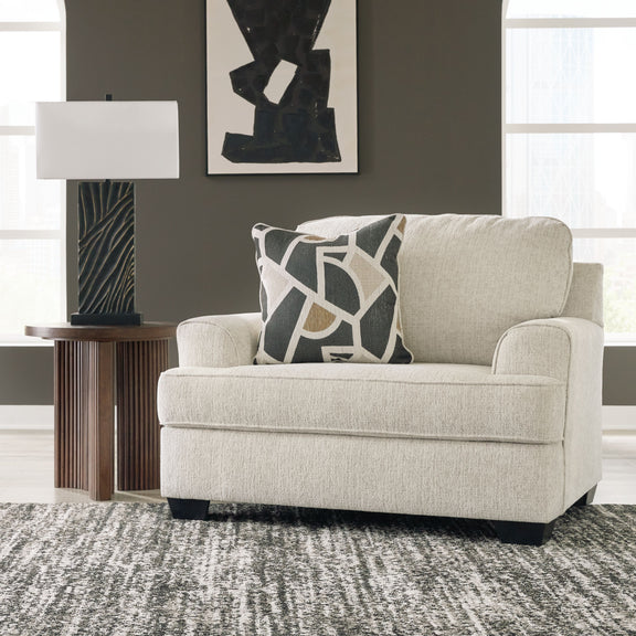 Light gray chair and a half with geometric throw pillow