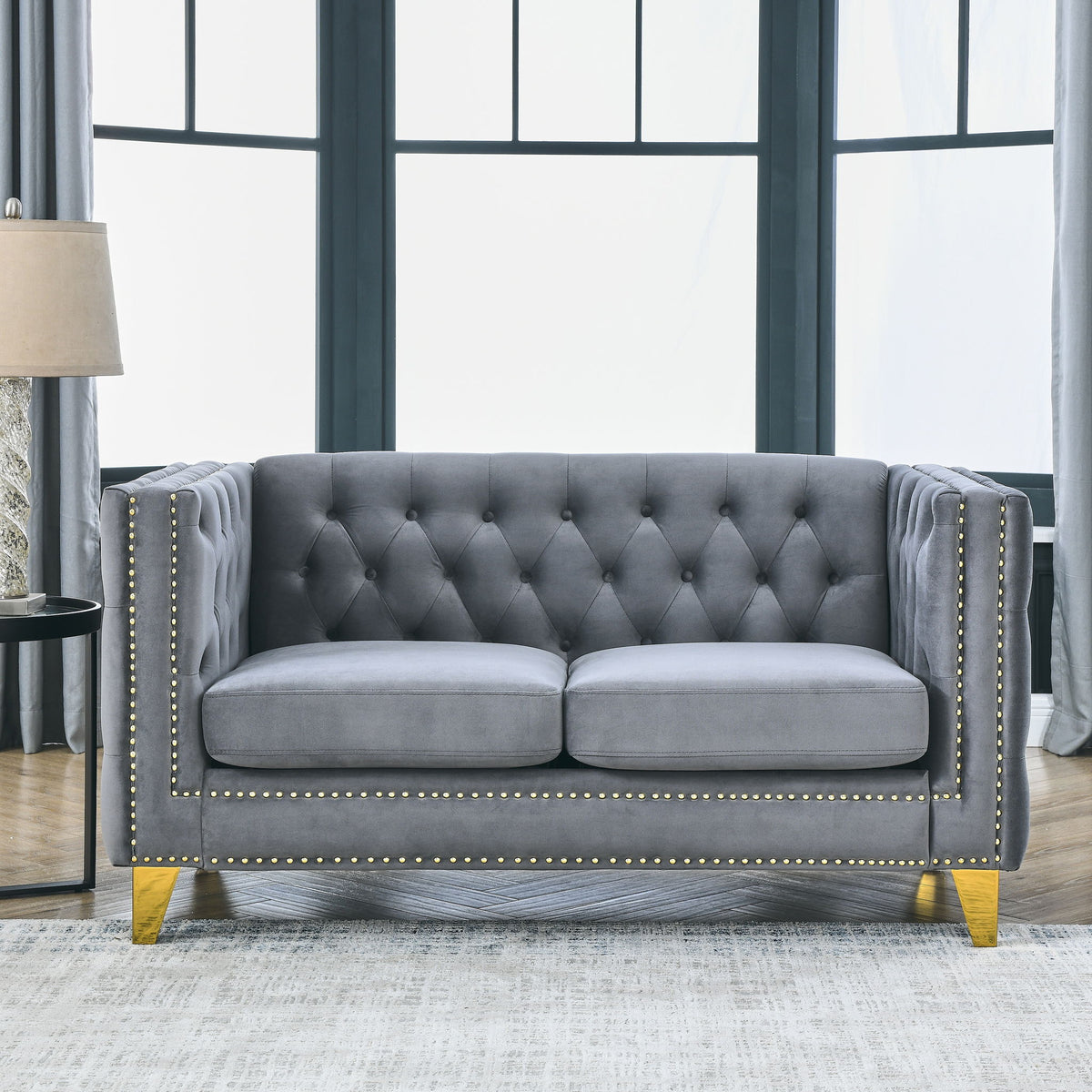 Dark gray button-tufted 3-seat sofa with rolled arms and gold nailhead trim