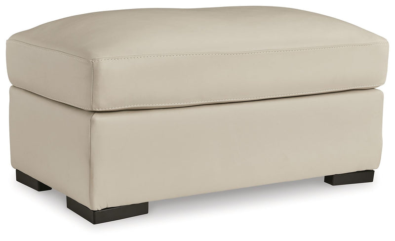 Almond upholstered ottoman with cushioned lid and dark block feet