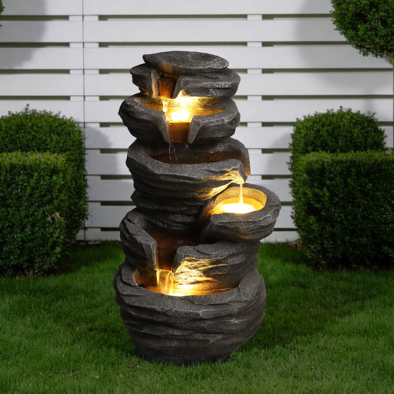 Gray stone-look waterfall fountain with glowing LED lights and multiple water tiers