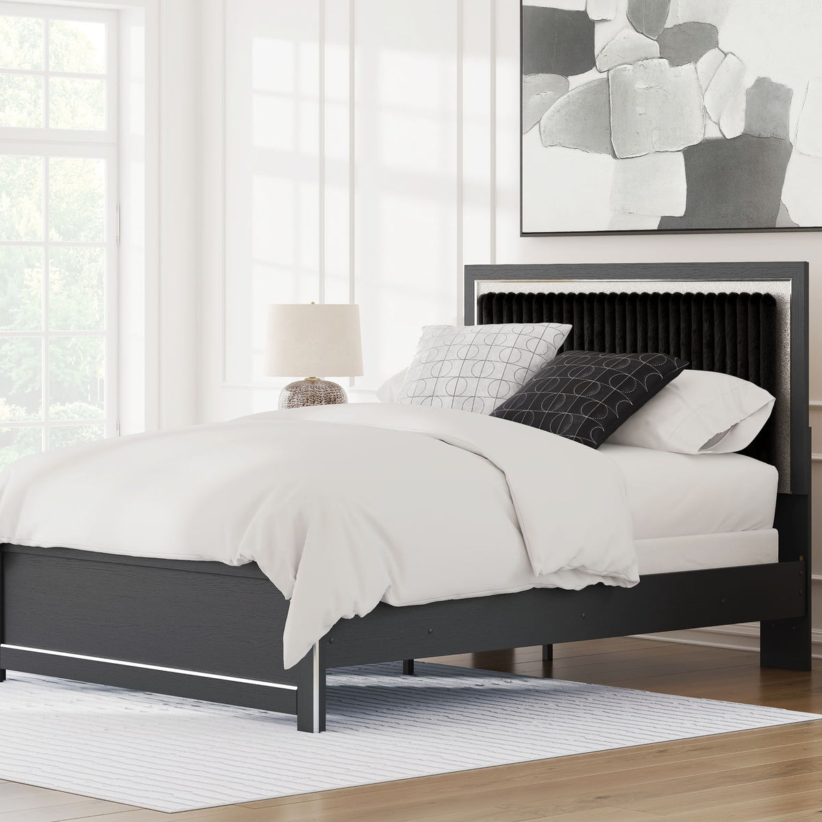 Upholstered panel bed with dark frame, upholstered headboard, and white bedding in a room scene.