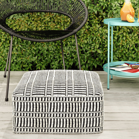 Black and white woven square pouf shown outdoors
