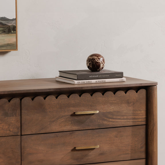 Brown dresser with rounded scalloped apron, two drawers, and gold bar handles