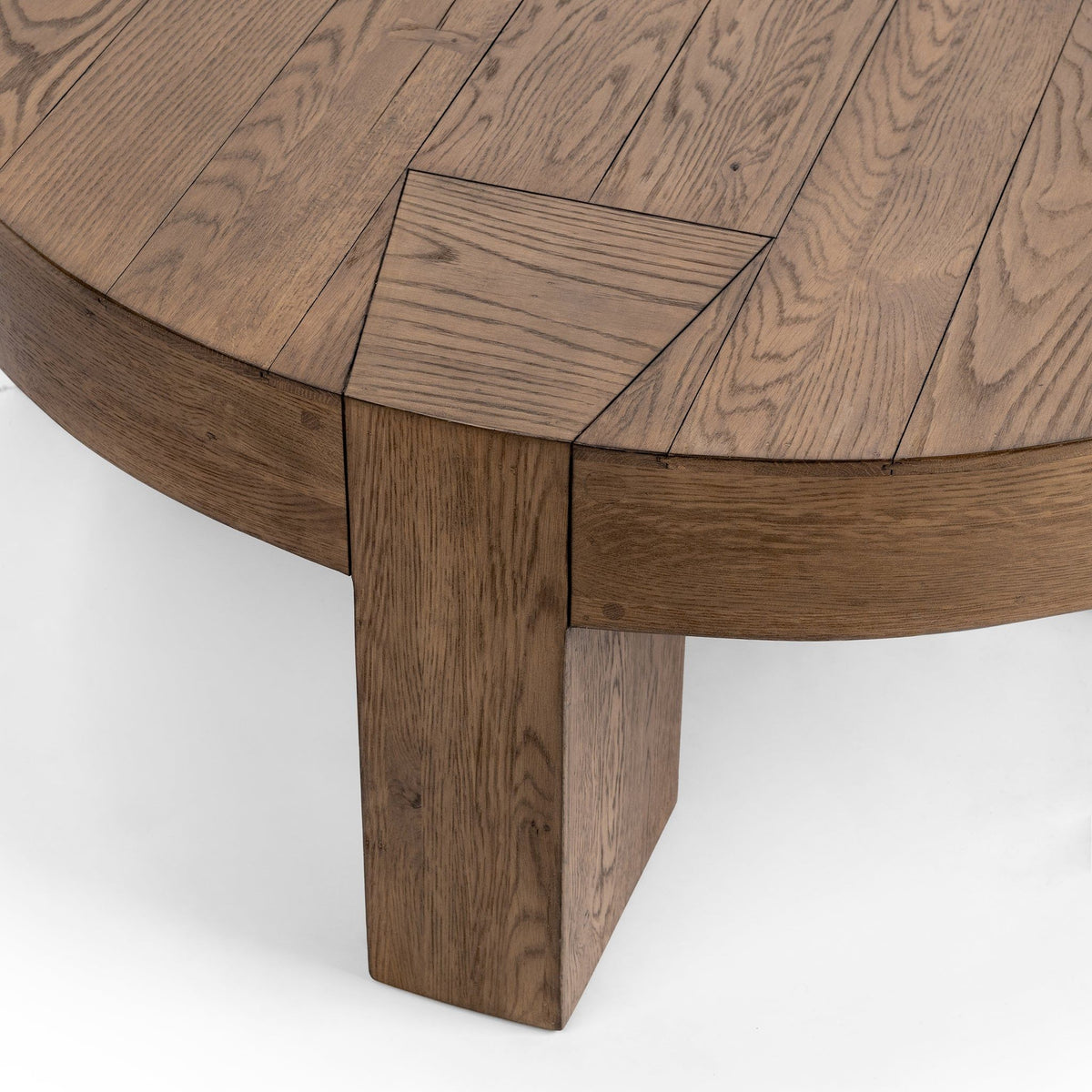 Corner view of cafe brown round coffee table showing wood grain and sturdy leg