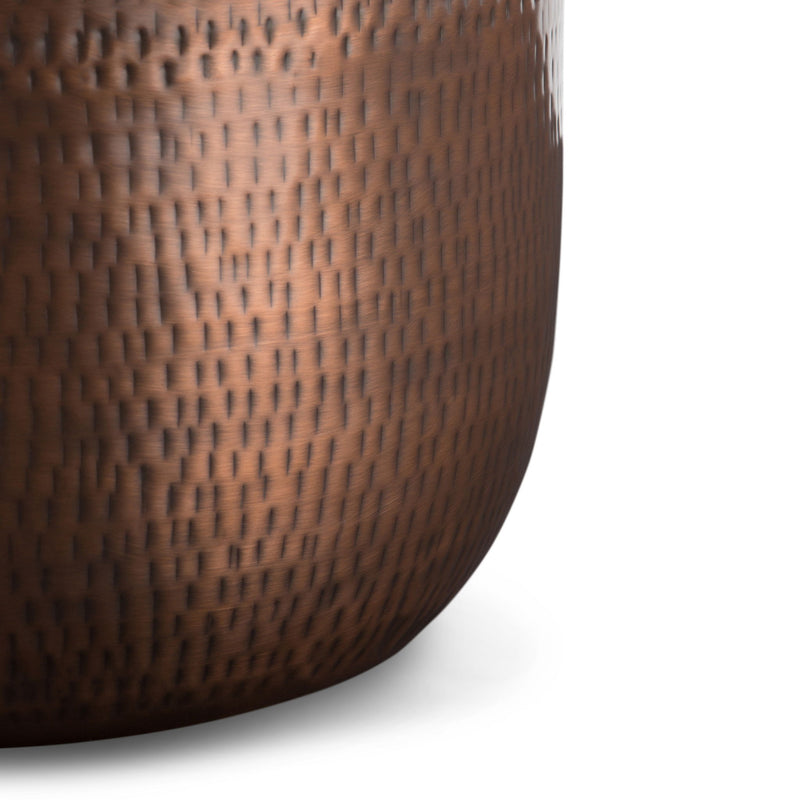 Bronze metal storage accent table close-up of hammered texture drum surface