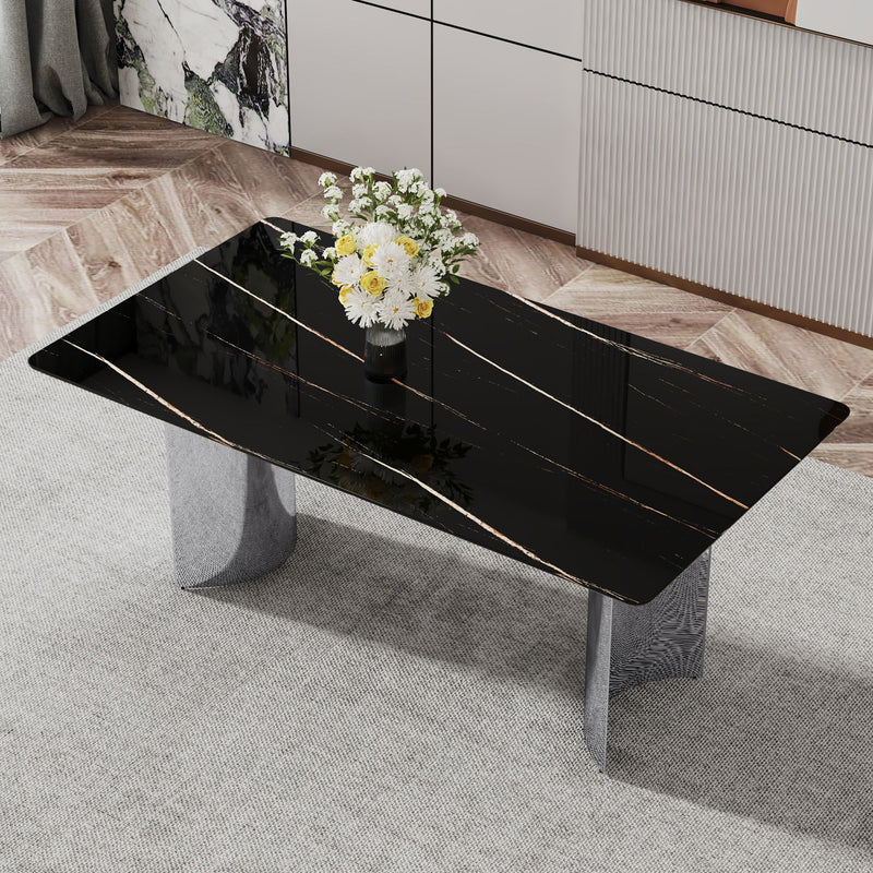 Black marble-look glass dining table with chrome pedestal legs, angled view
