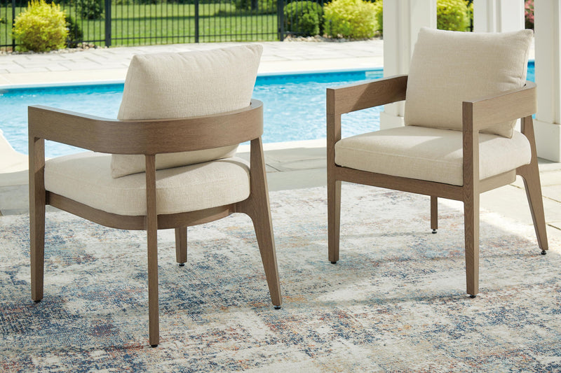 Two dark brown arm chairs with beige cushions