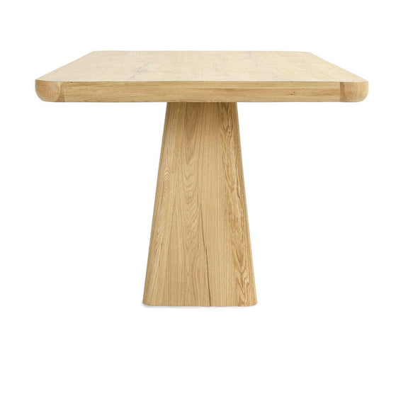 Natural wood dining table with slightly rounded rectangular top and central pedestal