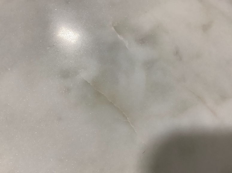 Close-up of white marble tabletop with subtle gray veining