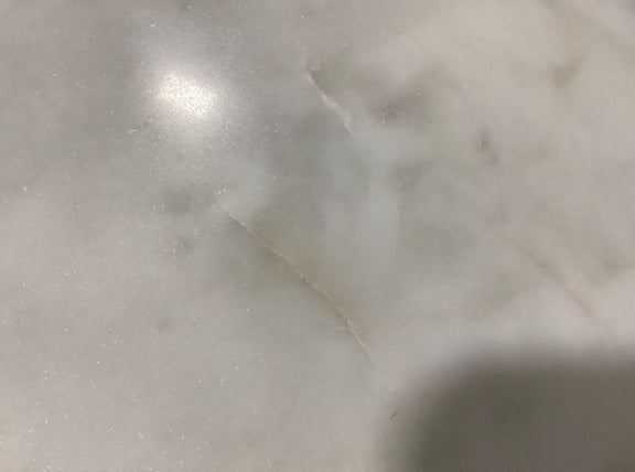 Close-up of white marble tabletop with subtle gray veining