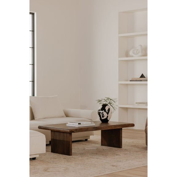 Brown wooden coffee table in front of white sofa, showing side profile