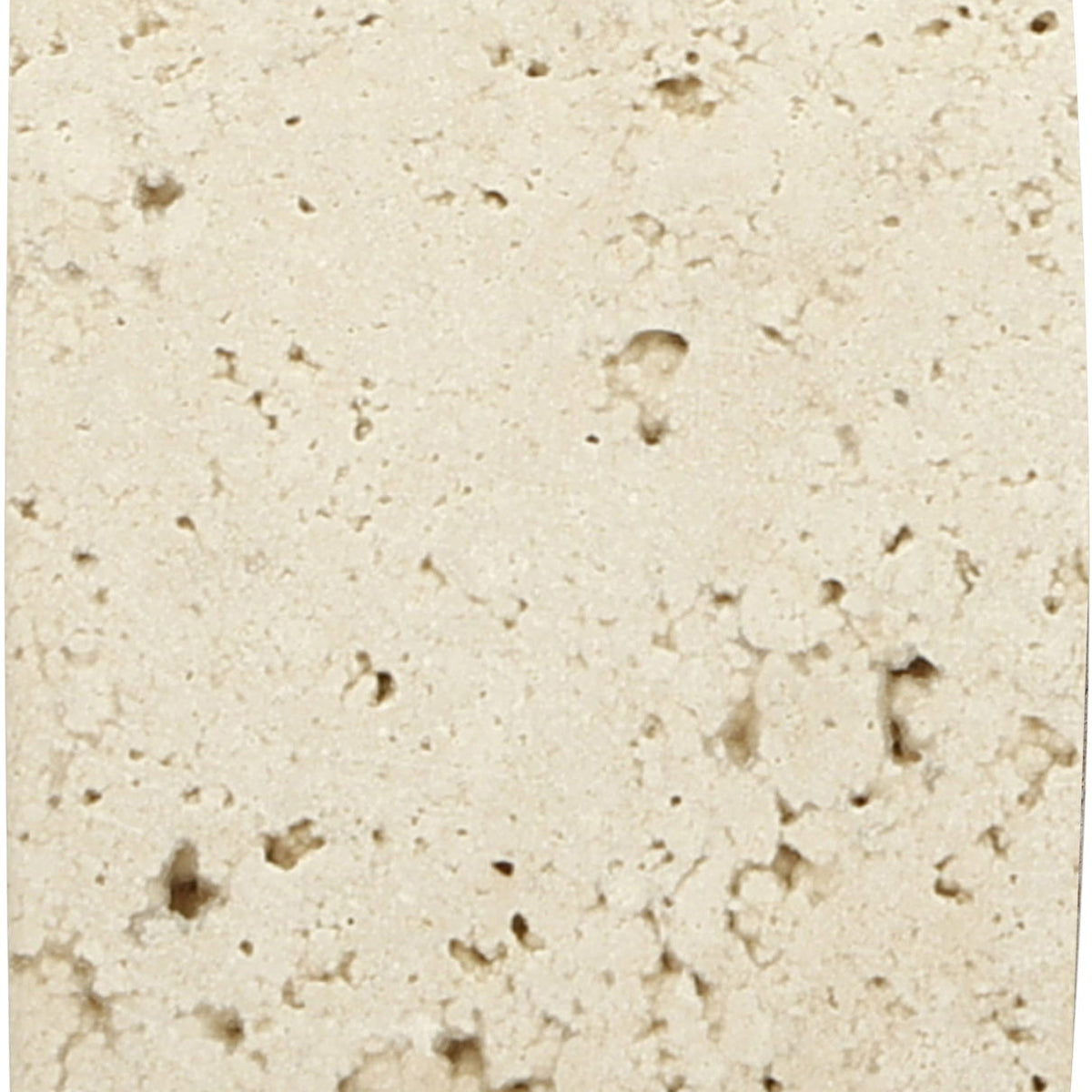 Beige travertine bookend close-up, speckled stone texture on solid back