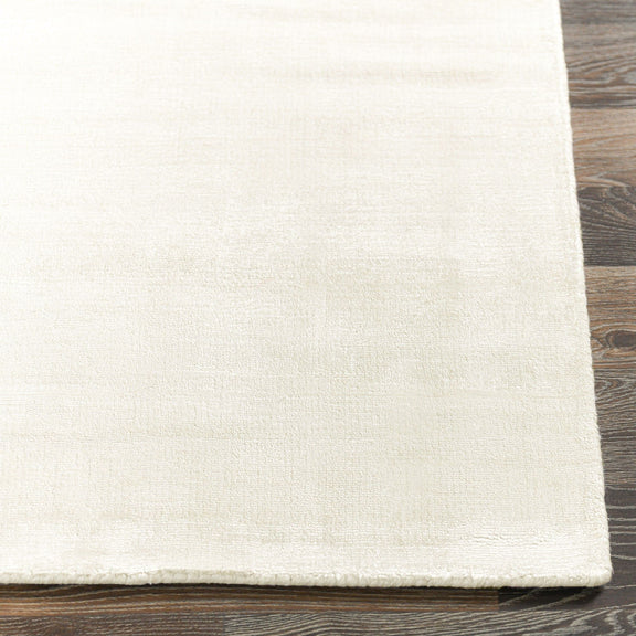 Light ivory textured area rug with straight hem and flat weave