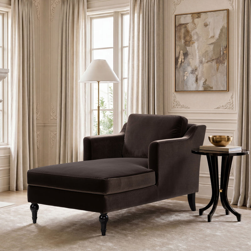 Dark brown upholstered chaise lounge with low seat, rounded backrest, and turned feet