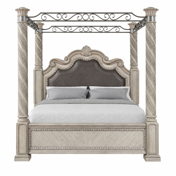 Gray king panel canopy bed with ornate metal scrollwork, four posts, and upholstered headboard