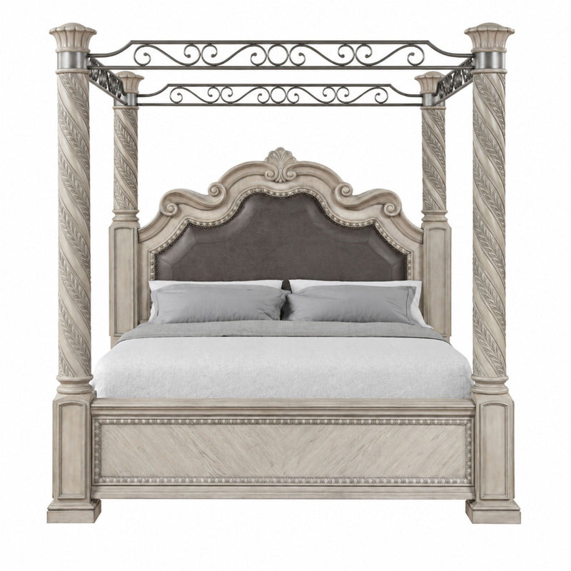 Gray king panel canopy bed with ornate metal scrollwork, four posts, and upholstered headboard