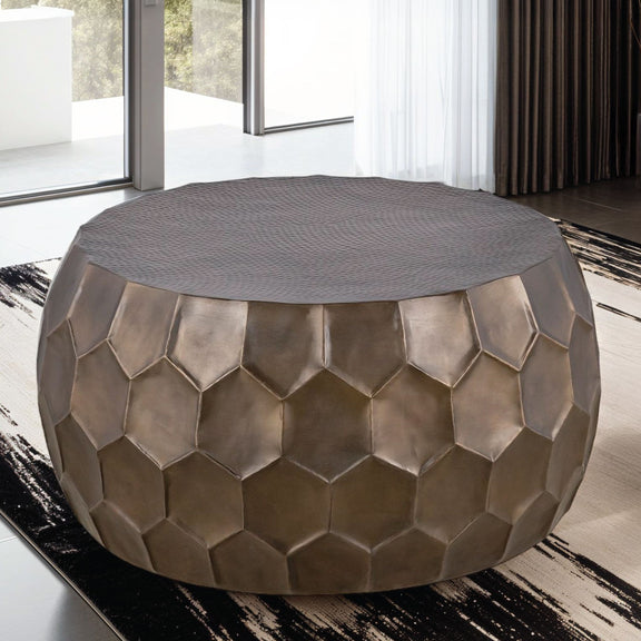 Round coffee table, 3/4 view, bronze hex metal sides and gray fabric top