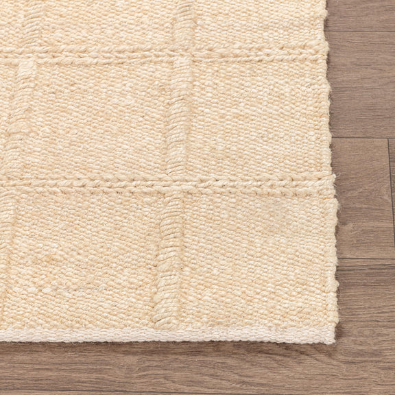 Cream jute area rug close-up showing small grid texture and flat pile