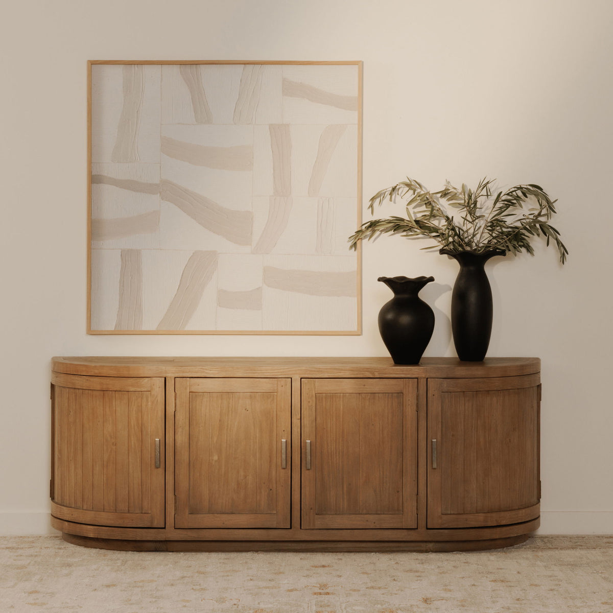 Natural wood media cabinet with four doors, curved base, and tall vertical metal pulls