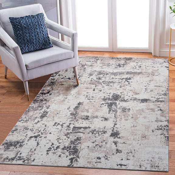 Abstract area rug with light gray and blue distressed pattern across rectangle