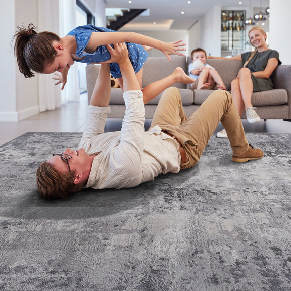 Light gray abstract area rug in living room, children and adults play on it