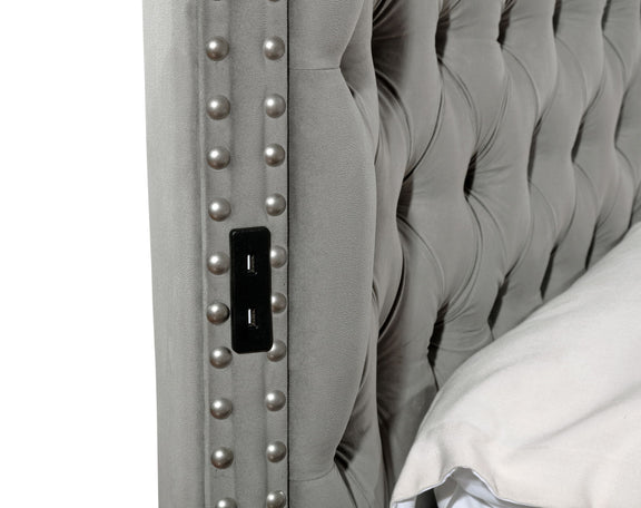 Gray upholstered bed panel with button tufting and built-in USB charging port