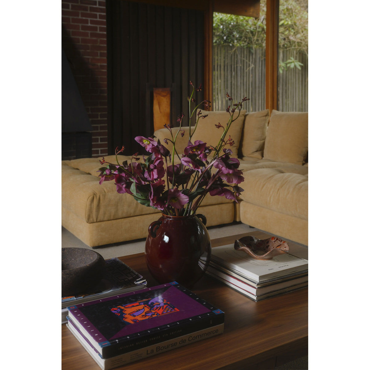 Walnut brown coffee table with rectangular top, shown from the front with books.