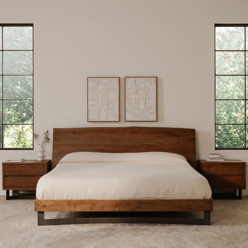 Smoked wood nightstand with two drawers beside bed and dark angled base