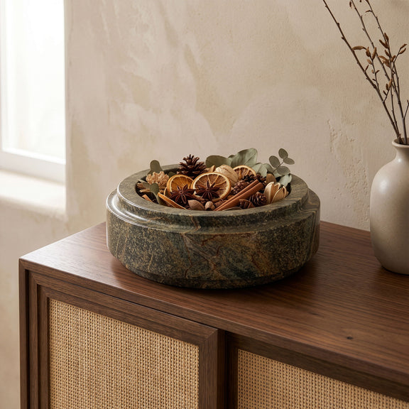 Green marble bowl with rounded rim, holding dried botanical arrangement inside.