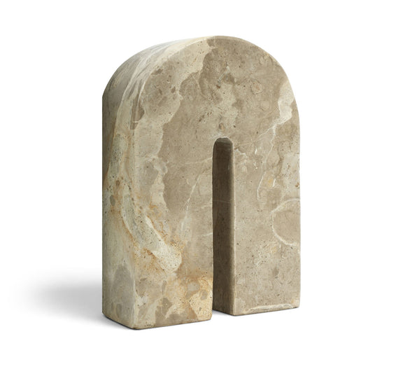 Light beige marble bookend with tall arched cutout, angled view