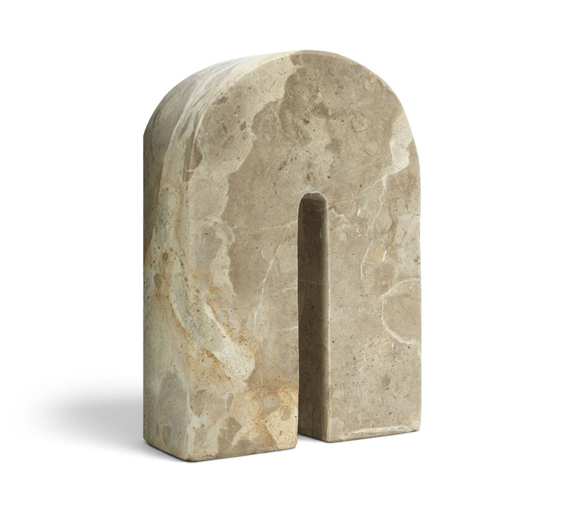 Light beige marble bookend with tall arched cutout, angled view