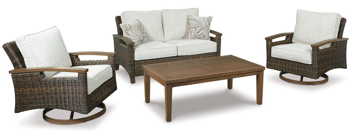 Wicker loveseat with beige cushions, two matching chairs, and a dark wood coffee table
