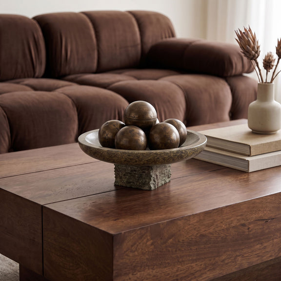 Genuine marble bowl centerpiece with dark green mottled stone pedestal on wooden table.