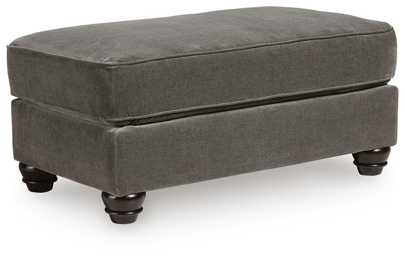 Dark gray fabric ottoman with padded top and black turned legs