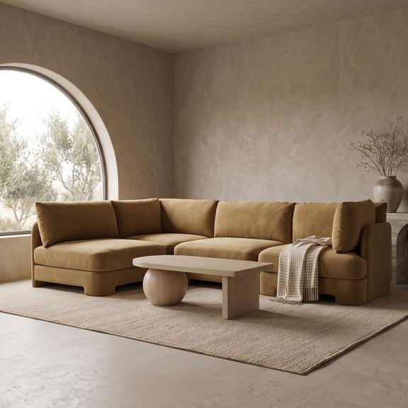 Tan velvet armless sectional sofa with rounded arms and tufted back cushions