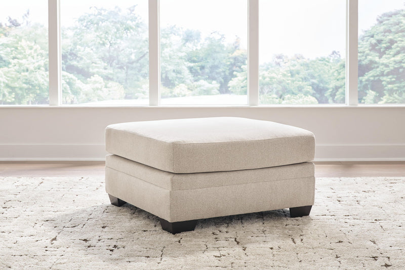 Light beige oversized ottoman with wide seat and dark block legs