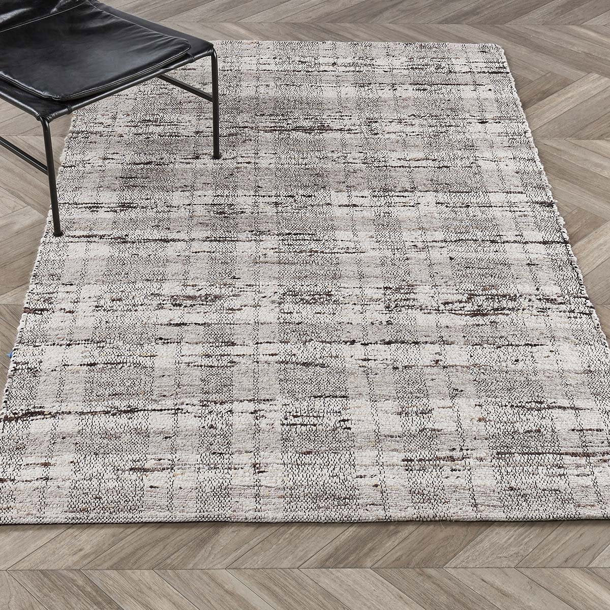 Distressed light gray area rug with subtle horizontal lines and woven texture