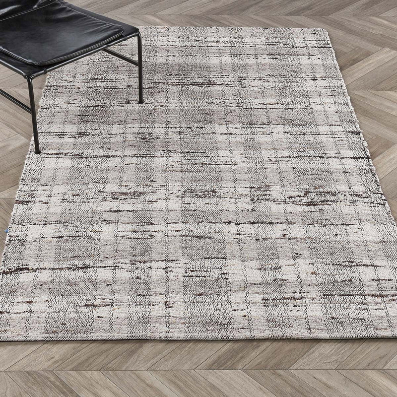 Distressed light gray area rug with subtle horizontal lines and woven texture
